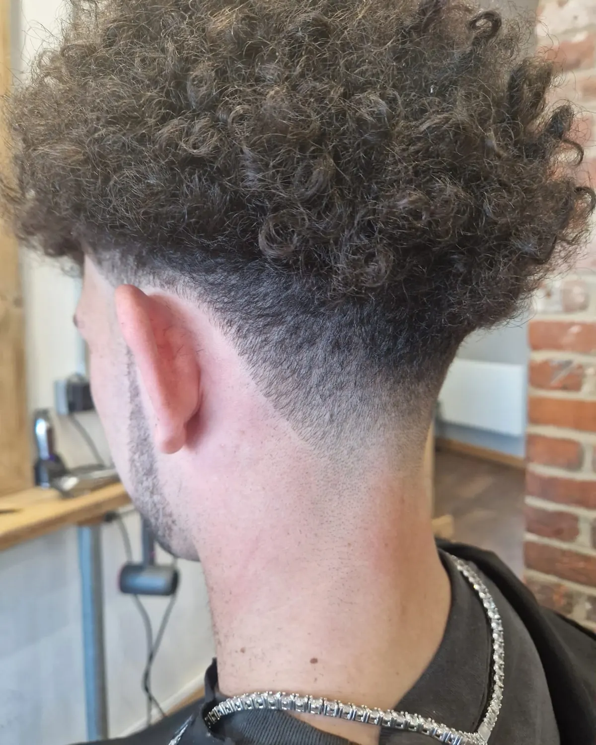 Curly top left long with a tapered back and sides, cut at Primo Hair Lounge Ipswich